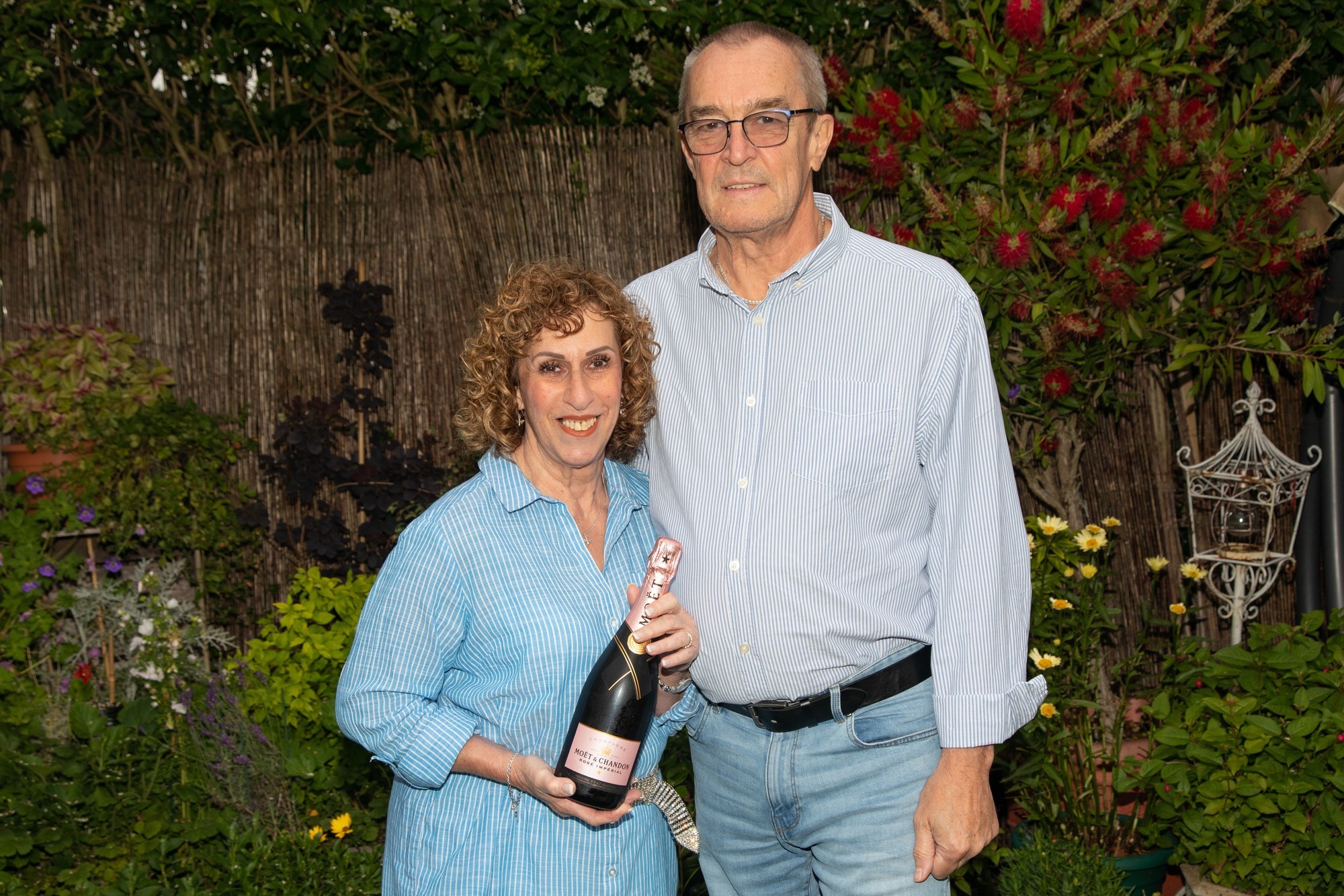 Amanda and John celebrate with bottle of bubbly 1