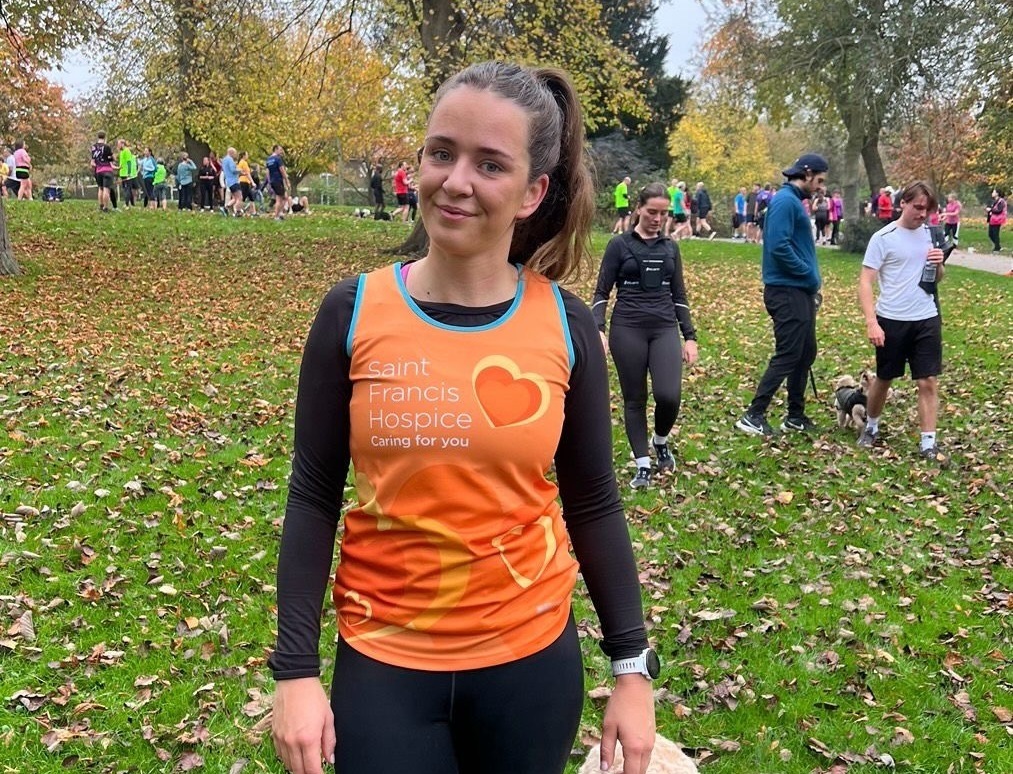 Erin in her Saint Francis Hospice running vest with her dog Cooper (cropped)