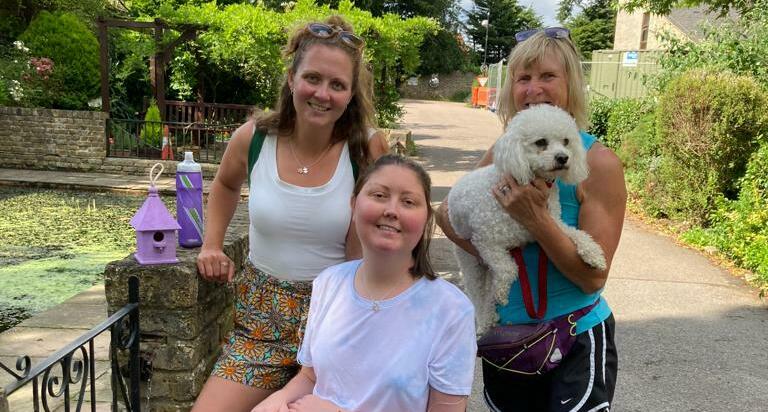 Ria by the Victorian pond at the hospice with Kaz, her mum and dog (cropped)