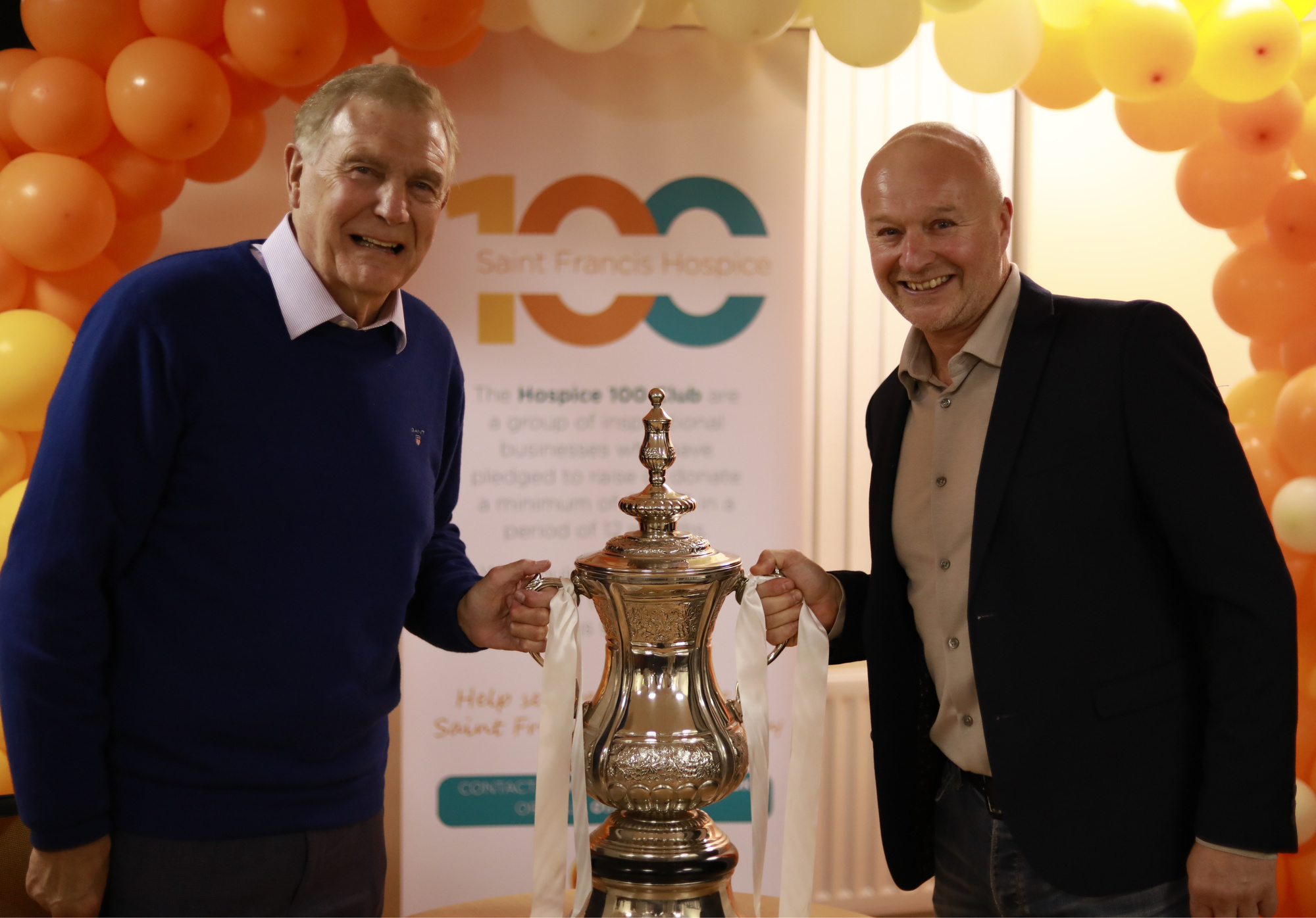 Sir Trevor Brooking with Steve Drew of Drew and Son Independent Family Funeral Directors holding a r